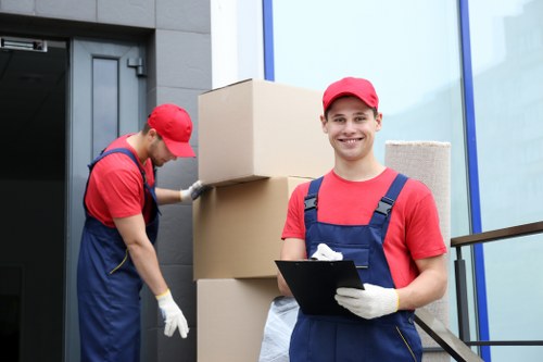 Employees loading moving equipment under a modern slavery compliance banner